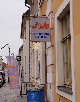 Außenansicht des JoJo Trekkingladens in der Gutenbergstraße in Potsdam mit Ladenschild und Wimpeln